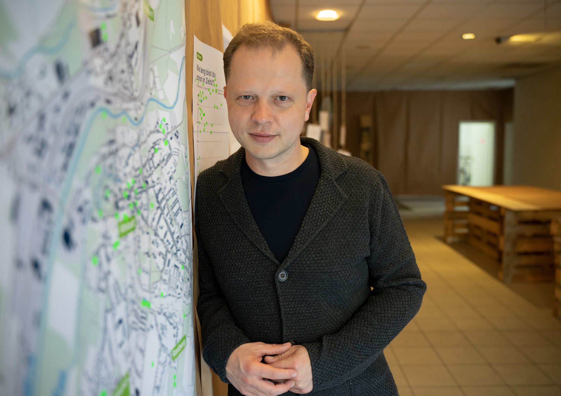 Robert Matzke, an eine Wand mit Stadtplan gelehnt, bei einem Beteiligungsprojekt